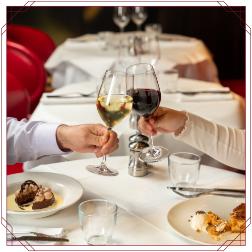 Guests toasting with red and white wine beside desserts at Bistrot at Wild Honey